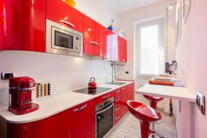 a red kitchen with red cabinets and a microwave at Pop Luxury Experience in Milan