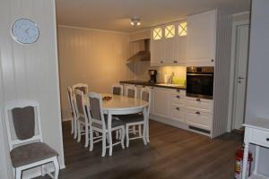 a kitchen with a table and chairs and a clock at Best of Lyngen panorama apartment in Lyngseidet