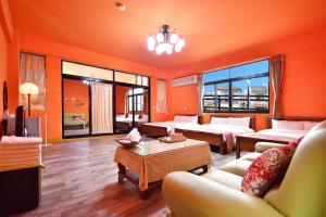 - un salon avec des murs orange, un canapé et une table dans l'établissement Heng Bin Bed and Breakfast, à Taïtung