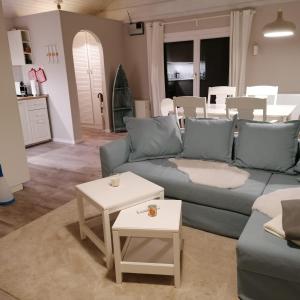 uma sala de estar com um sofá azul e duas mesas em Wohlfühloase Villa Sunshine an weißem Sandstrand em Dahme
