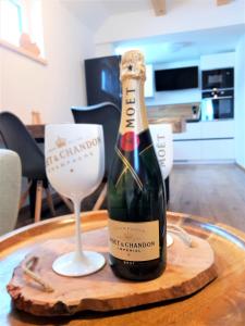 WOOD HOME - Luxury Mountain Apartment في هورني مالا أوبا: زجاجة من الشمبانيا وكأس من النبيذ على الطاولة