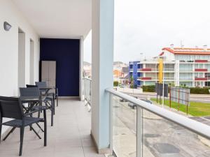 a balcony with chairs and tables on a building at Beautiful Apartment in S o Martinho do Porto with Balcony in São Martinho do Porto