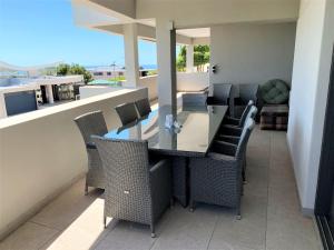 a patio with chairs and a table on a balcony at 6 on Clifton - Spacious 2 bedroom apartment in Cape Town