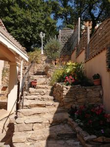 un chemin en pierre menant à une maison fleurie dans l'établissement "Chênes et Romarins", Calme, Ombrage, Nature, à Bagnols-sur-Cèze