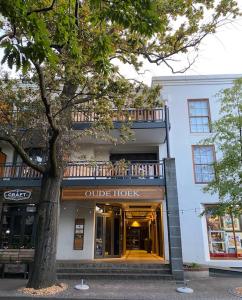 a store front of a white building with a tree at Lemon Rind - 205 Oude Hoek in Stellenbosch