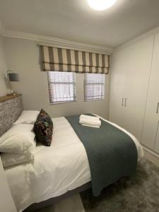 a bedroom with a bed with two pillows on it at Lemon Rind - 205 Oude Hoek in Stellenbosch