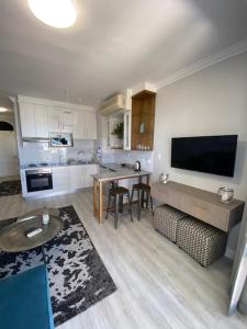 a living room with a kitchen with a large television at Lemon Rind - 205 Oude Hoek in Stellenbosch