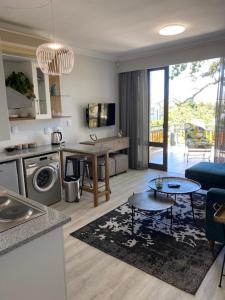 ein Wohnzimmer mit einer Küche und ein Wohnzimmer mit einem Tisch in der Unterkunft Lemon Rind - 205 Oude Hoek in Stellenbosch
