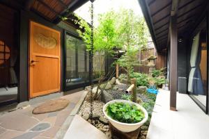 a garden with a plant in a pot on a porch at Takeya Kitano Honkan in Kyoto