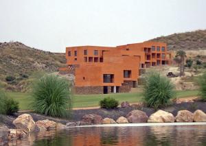 eine Ausstellung eines Hauses mit einem See davor in der Unterkunft Preciosa Casa de diseño Valle del Este Golf Resort ideal para familias in Vera