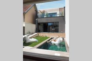 une maison avec une piscine entourée de chaises pour 2 personnes dans l'établissement Le Clos des Jardins, à Dijon