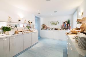 a kitchen with white cabinets and a blue floor at Hotel Zum Eisenhammer in Oberhausen