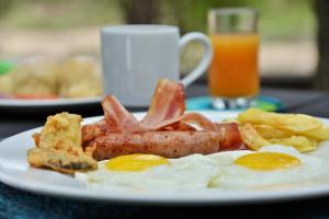 a plate of breakfast food with eggs bacon and chips at Rhino Walking Safaris in Skukuza
