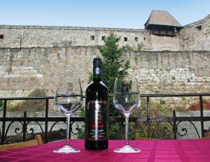 a bottle of wine sitting on a table with two wine glasses at Arany Barokk Apartman in Eger