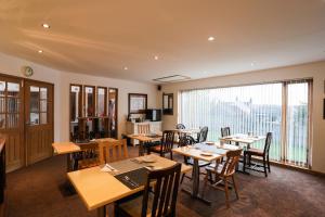 a restaurant with tables and chairs and a large window at Crackin View Guest House in Hexham