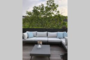 a white couch on a patio with a table at Schicke Landhauswohnung mit Dachterrasse in Königswinter