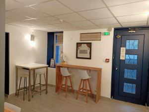 a room with a table and stools and a blue door at Hôtel Raphael Prado in Marseille