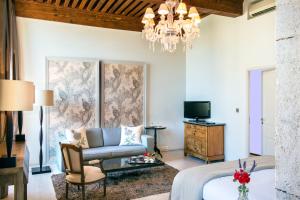 a living room with a bed and a chandelier at Château De Massillan in Uchaux