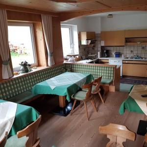 Selbstversorger Unterkunft ZOLLER Sommerbergbahn inklusive في تانهايم: مطبخ مع طاولة وكراسي في غرفة