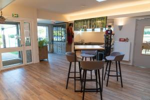 a room with a table and some stools at VVF Normandie Veules-les-Roses in Veules-les-Roses