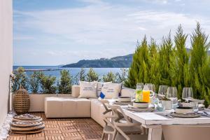 een patio met een bank en een tafel en stoelen bij Shapes Luxury Suites in Ermoupoli