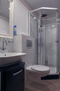 uma casa de banho com um chuveiro, um WC e um lavatório. em Loff Hotel em Ecaterimburgo