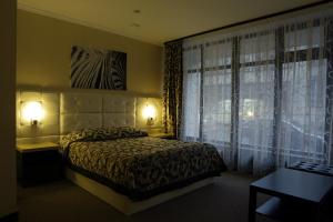 a bedroom with a bed and a window with curtains at Loff Hotel in Yekaterinburg