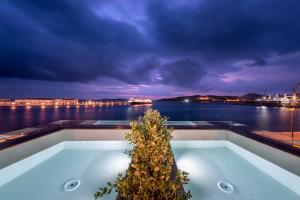 uma banheira com uma planta no meio em Shapes Luxury Suites em Ermoupoli