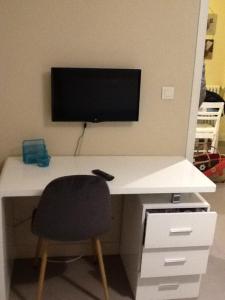 a desk with a television and a chair in a room at Le Clos Domenat 3 in Brive-la-Gaillarde