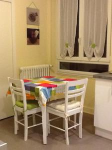 a table and two chairs with a colorful blanket on it at Le Clos Domenat 3 in Brive-la-Gaillarde
