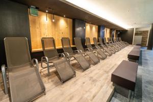 - une rangée de chaises dans une chambre dotée de murs en bois dans l'établissement Lady Maria Hotel Wellness & Resort, à Fondo