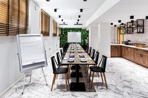 una mesa larga con sillas y una tabla blanca en 31 Doors Hotel, en Alexandroupoli
