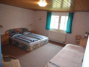 ein kleines Schlafzimmer mit einem Bett und einem Fenster in der Unterkunft Feriengut Dietzsch in Pöritzsch