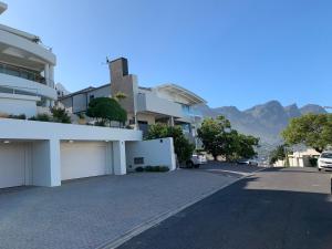 an empty street with buildings and mountains in the background at 6 on Clifton - Spacious 2 bedroom apartment in Cape Town