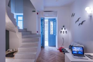 Habitación con escalera y escritorio con ordenador portátil. en Shapes Luxury Suites, en Ermoupoli