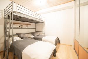 twee bedden in een kamer met twee stapelbedden bij Holiday Home Etelärinne E - Ruka Jurmuntie 10 in Kuusamo