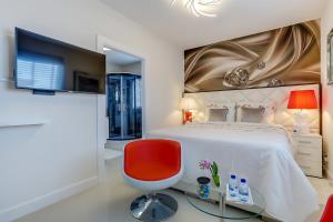 um quarto com uma cama grande e uma cadeira vermelha em B&B Modern Times em Amsterdã