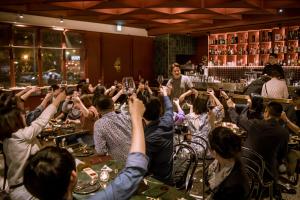 a group of people raising their glasses in a bar at Getcha Hostel in Taichung