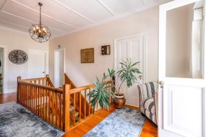 un salon avec un escalier et une plante en pot dans l'établissement No.10 Caledon Street Guest House, à George