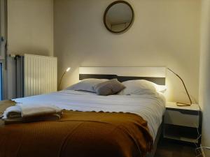 um quarto com uma cama grande e um espelho na parede em Résidence Hôtelière Laudine em Reims