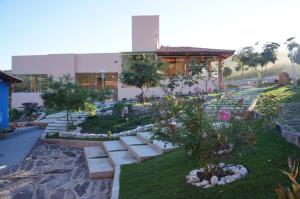 un jardín con bancos y árboles y un edificio en Pousada Flor de Lótus, en Ibicoara