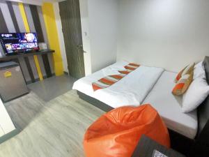 um quarto de hotel com duas camas e uma televisão em Riski Residence Bangbuathong em Nonthaburi