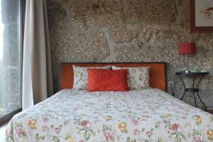 a bed with a red pillow in a bedroom at Eira House - Quinta de Fundevila in Vieira do Minho +67 photos