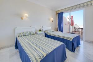 2 łóżka w pokoju hotelowym z balkonem w obiekcie Vivienda Vacacional Los Gigantes w mieście Santiago del Teide