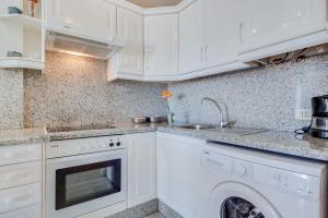 biała kuchnia ze zlewem i zmywarką w obiekcie Vivienda Vacacional Los Gigantes w mieście Santiago del Teide