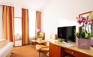 a hotel room with a desk with a flat screen tv at Hotel Dana 2 in Satu Mare