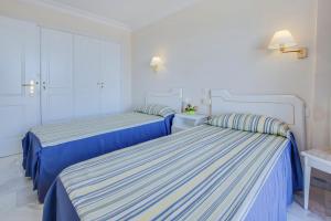 2 łóżka w pokoju z niebiesko-białą pościelą w obiekcie Vivienda Vacacional Los Gigantes w mieście Santiago del Teide +13 zdjęć