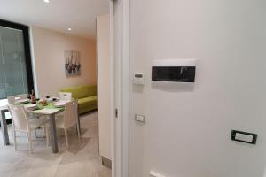 een woonkamer met een tafel en een tv aan de muur bij Beautiful Holiday Apartment “casa Susanna Deluxe A Otranto” With Wi-fi & in Otranto