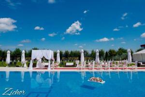 a view of the pool at a wedding with white chairs at Hotel Dana in Satu Mare