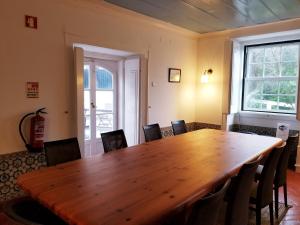 a large wooden table in a room with chairs at Casa do Arco in Sintra
